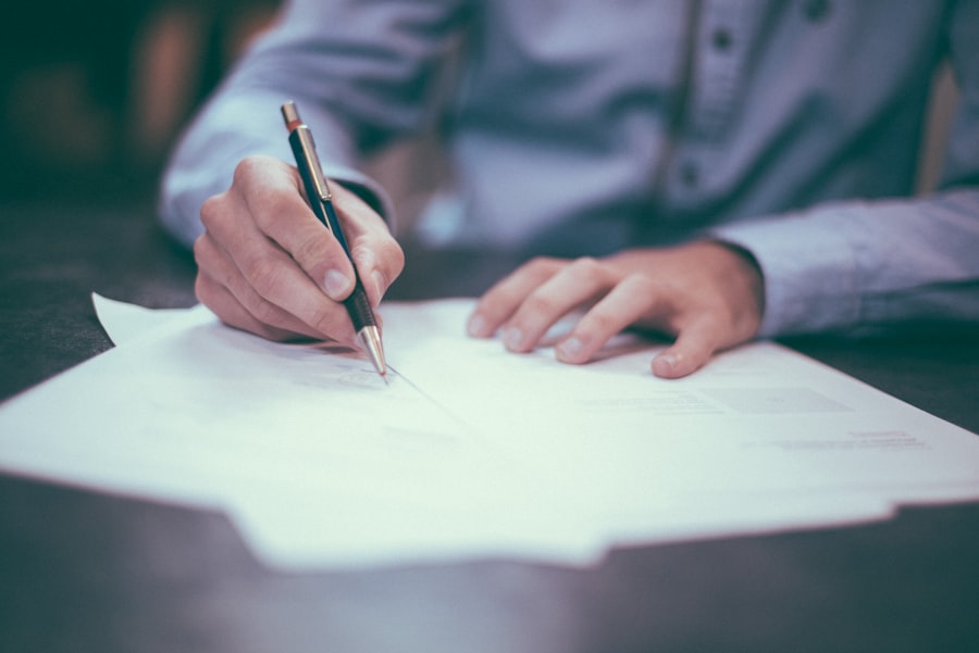 Two people reviewing and signing paperwork at a desk