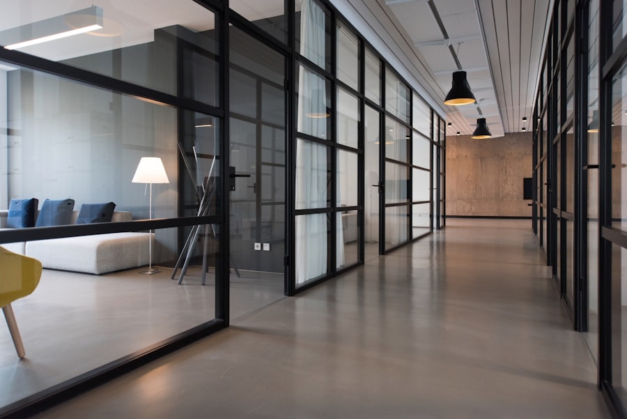 Glass-partitioned meeting rooms along a bright workplace corridor