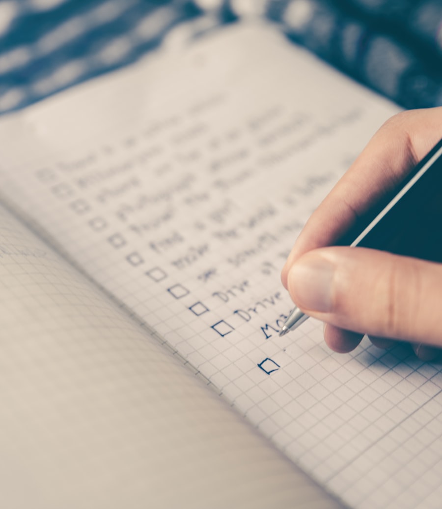A budget worked out by hand on paper beside a laptop